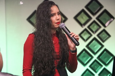 Handheld microphones lady, dressed in a red long-sleeved shirt
